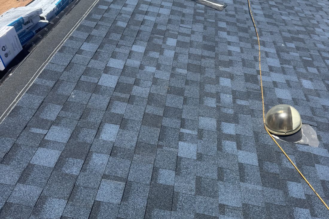 Roofing crew installing new architectural asphalt shingles on a Phoenix home